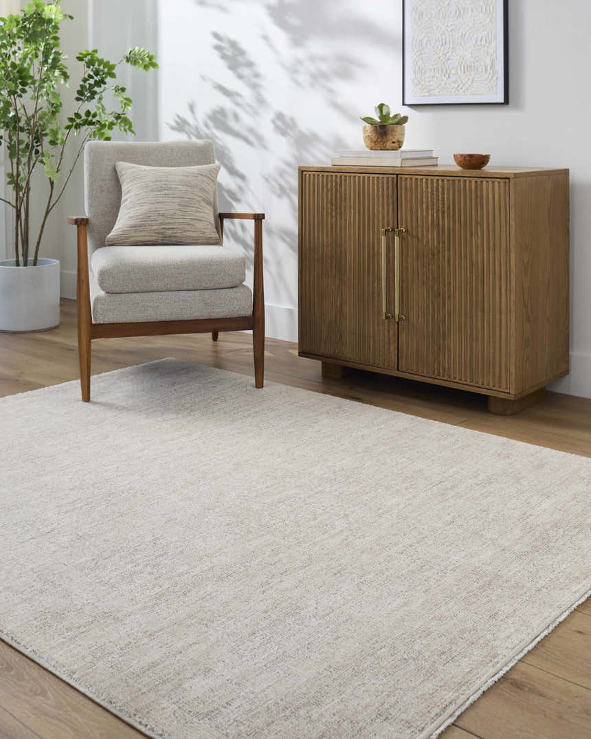 Living room scene with Livabliss x Galey Alix Maria Elena V Vintage Medallion Area Rug in ivory and tan, chair, and wood cabinet. Roomscene-Rectangle