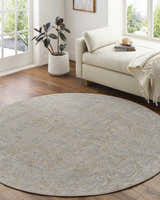 Light-filled room with a round Coby Cream Avant Garde rug, neutral chaise lounge, and wood floors. Roomscene-Round
