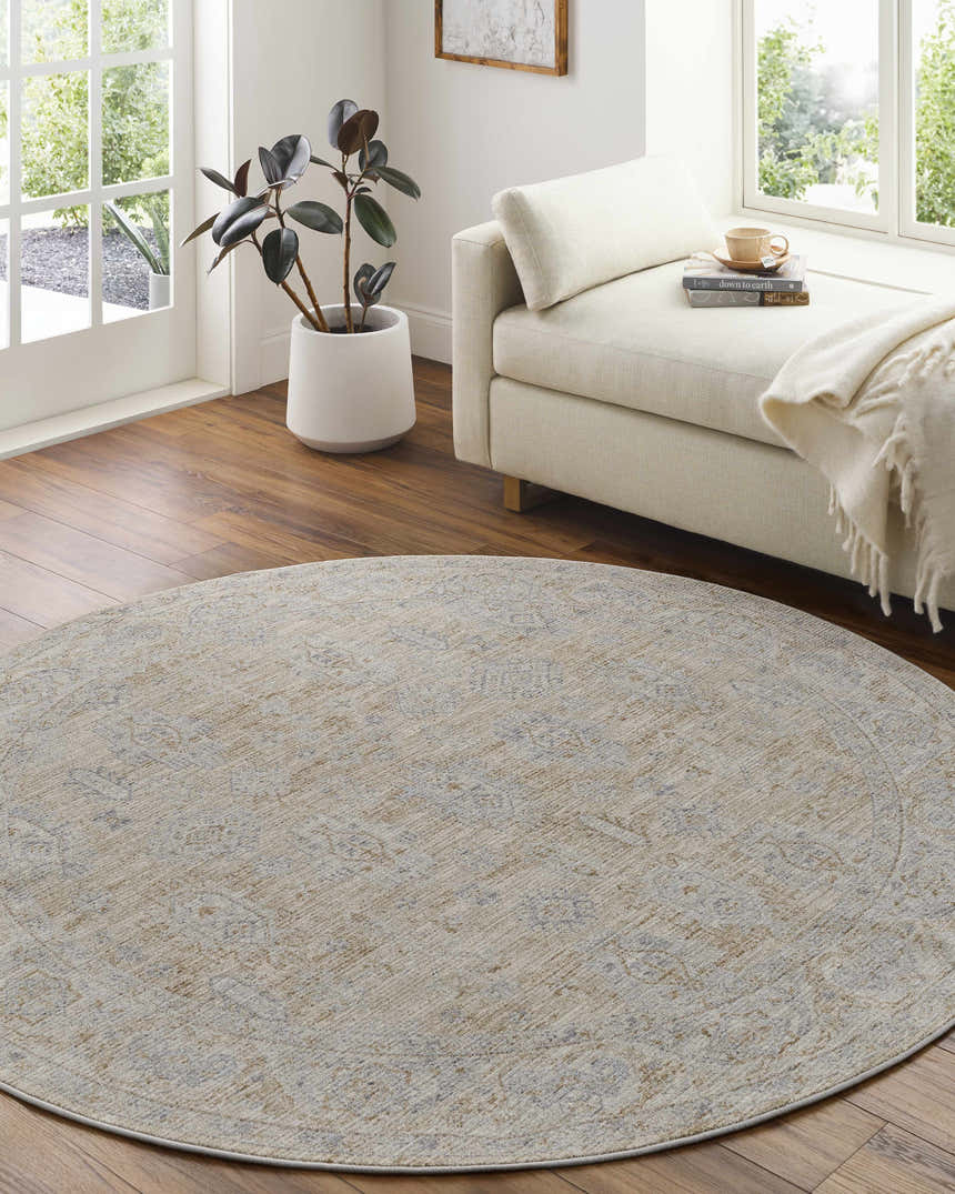 Light-filled room with a round Coby Cream Avant Garde rug, neutral chaise lounge, and wood floors. Roomscene-Round
