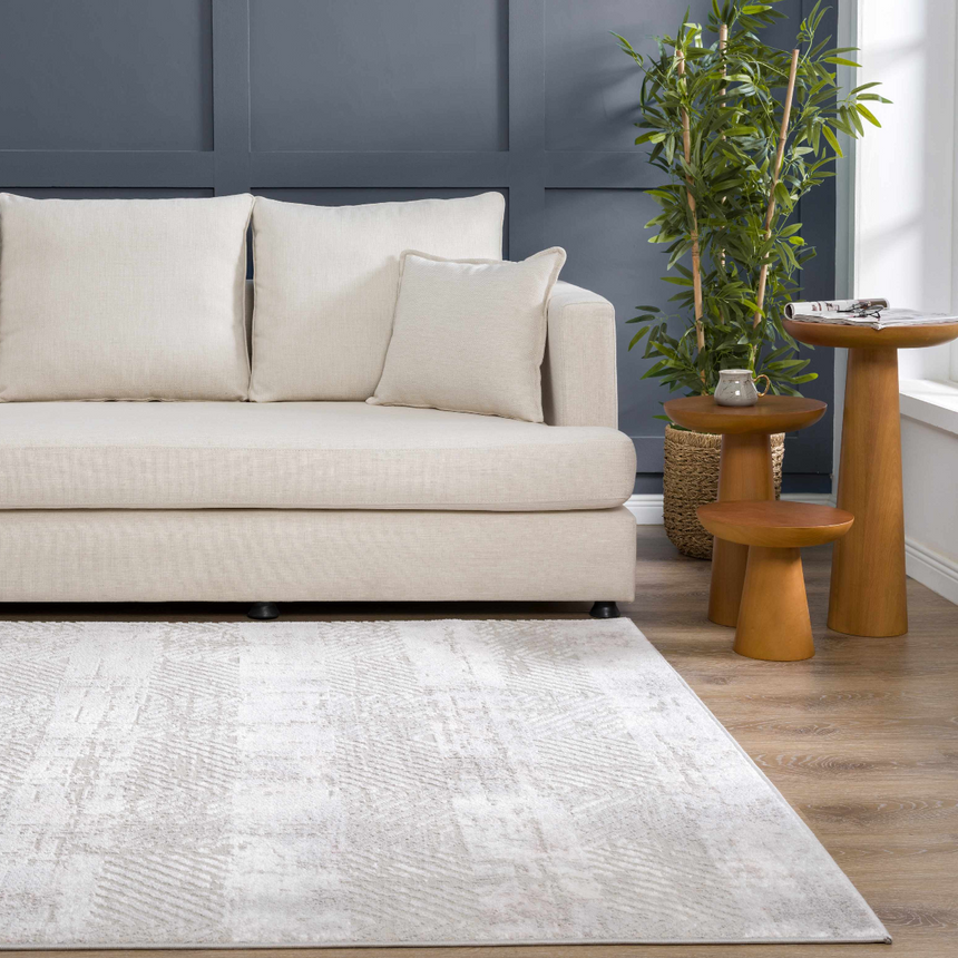 Living room scene with a Bucky Area Rug in gray and pink, complementing the neutral sofa and wood side tables. Roomscene-Rectangle