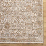 Close-up of the Andres Sage Area Rug. Traditional floral pattern in cream, tan, light brown, and blue colors. Corner