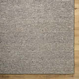 Close-up of the hand-tufted Winta Taupe Wool Area Rug showing its texture and neutral gray, tan, and sage colors. Corner