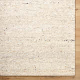 Close-up of the hand-tufted Winta Beige Wool Area Rug showing its creamy color, subtle texture, and wool fibers. Corner