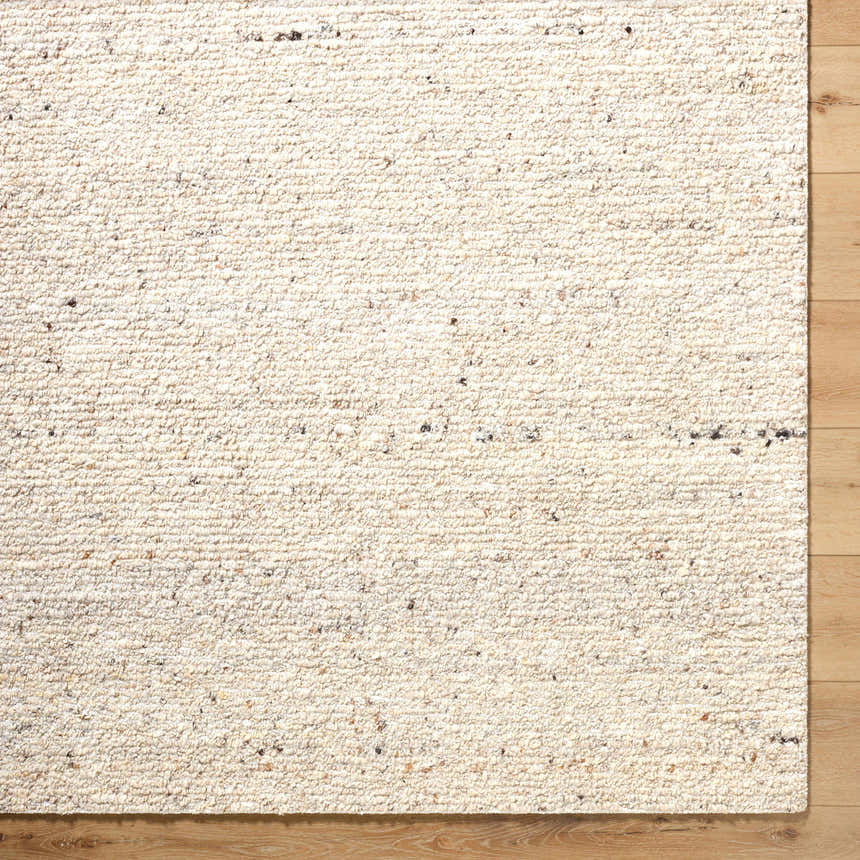 Close-up of the hand-tufted Winta Beige Wool Area Rug showing its creamy color, subtle texture, and wool fibers. Corner