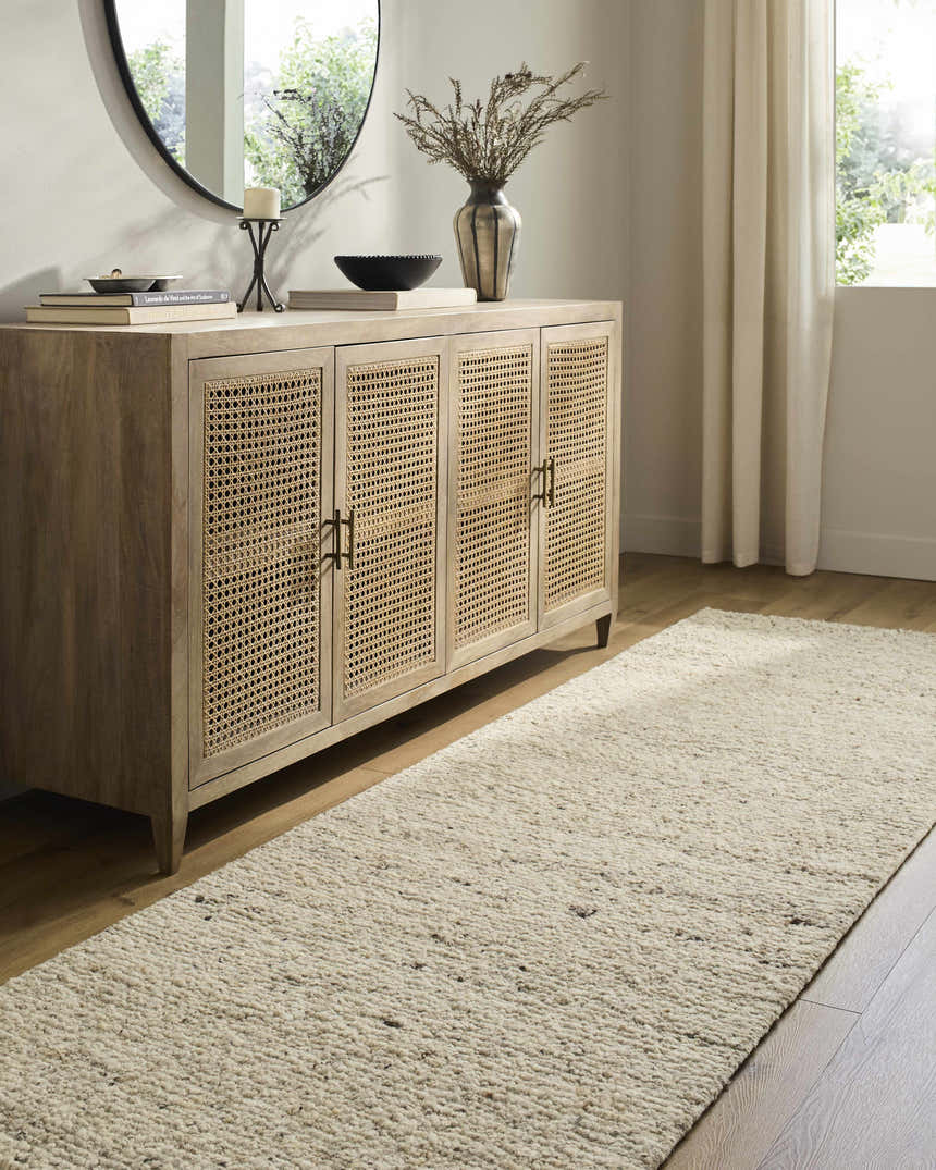 Living room scene with a Winta Beige Wool Area Rug, wood floors, and a console table with decor. Roomscene-Runner