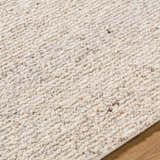 Close-up of the hand-tufted Winta Beige Wool Area Rug. Cream, ivory, and white tones with a subtle textured design. Texture