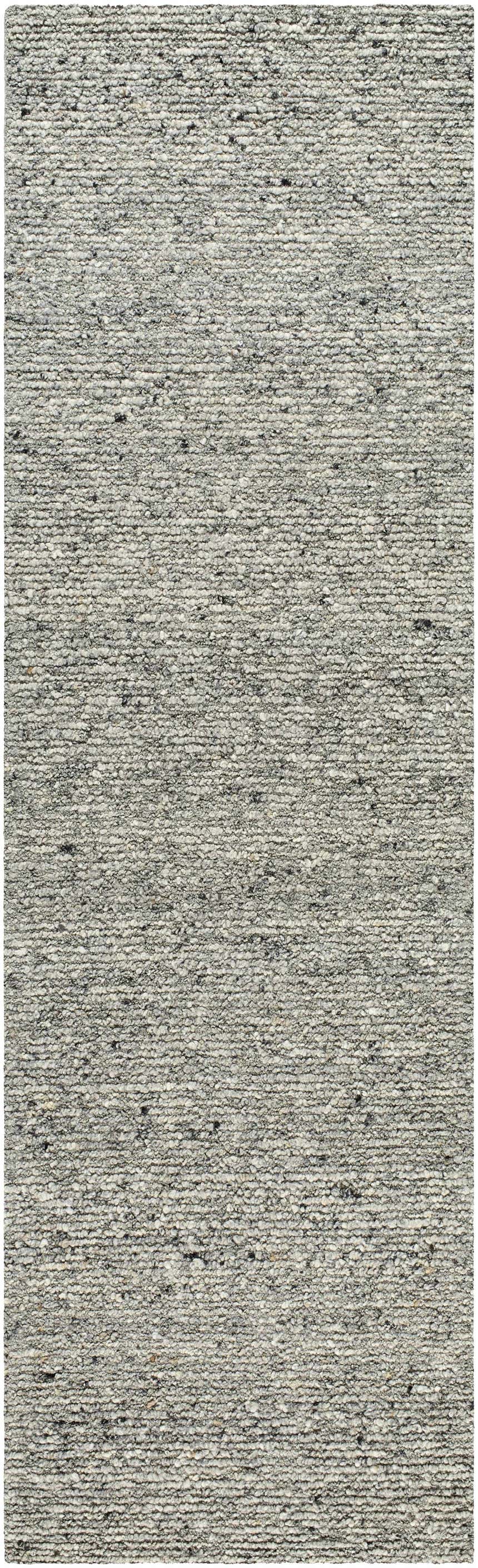 Close-up of the hand-tufted Winta Charcoal Wool Area Rug. The rug has a textured, looped pile with ash, gray, and silver gray tones. Design-Runner-310