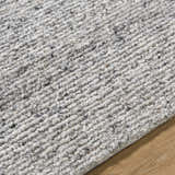 Close-up of the hand-tufted Winta Charcoal Wool Area Rug, showing its gray, ash, and silver gray tones and textured wool design. Texture