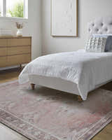 Bedroom scene with a beige Ussun Washable Area Rug, wood dresser, white bedding, and neutral artwork. Roomscene-Rectangle