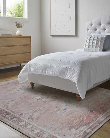 Bedroom scene with a beige Ussun Washable Area Rug, wood dresser, white bedding, and neutral artwork. Roomscene-Rectangle