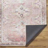 Close-up of the Ussun Washable Area Rug showing its dusty pink, beige, and brown traditional pattern and non-slip backing. Fold
