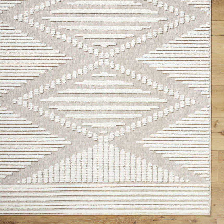 Close up of the Annika Washable Area Rug, a farmhouse style rug in off white and tan with a geometric diamond pattern. Corner