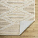Close-up of the Annika Light Brown 3D Washable Area Rug showing beige geometric pattern and texture on wood floor. Fold