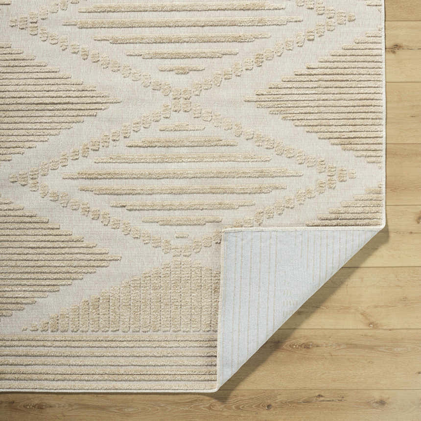 Close-up of the Annika Light Brown 3D Washable Area Rug showing beige geometric pattern and texture on wood floor. Fold