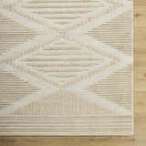 Close up of Annika Light Brown 3D Washable Area Rug. Beige and light brown rug with a geometric pattern and textured design. Corner