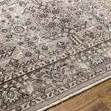 Close-up of the Lugo Luxe Area Rug showing its traditional oriental pattern and tassel detail in charcoal and light gray tones. Texture