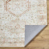 Close-up of the Laran Rust Distressed Washable Area Rug showing its ash, brick red, and light gray traditional pattern. Fold