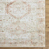 Close-up of Laran Rust Distressed Washable Area Rug showing traditional brick red, gray, and silver pattern on wood floor. Corner