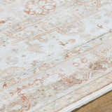 Close-up of the Laran Rust Distressed Washable Area Rug, showcasing its traditional pattern and brick red, light gray, and ash colors. Texture
