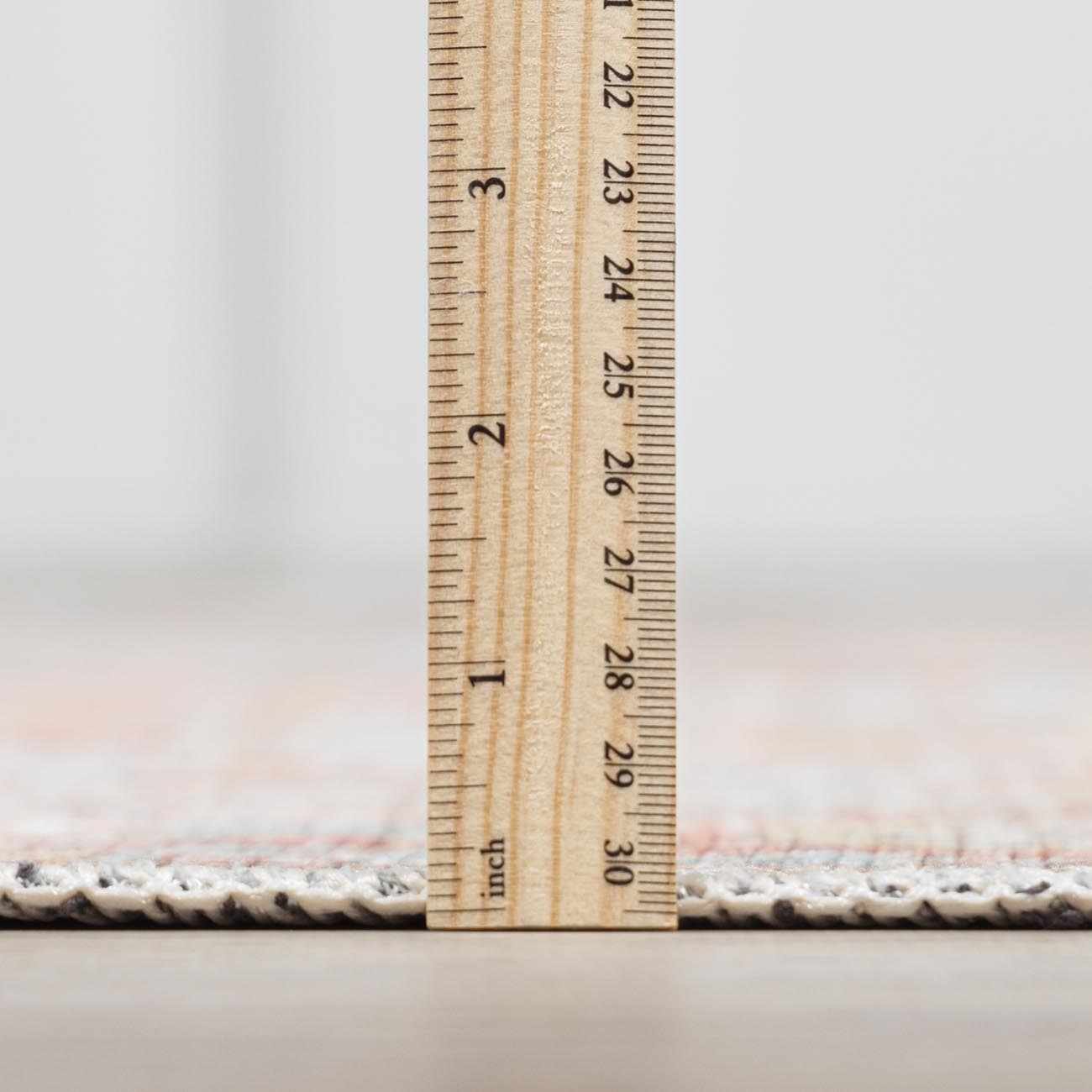Close-up of the Rust Maayon Washable Rug pile height, showing a low profile with brick red and brown colors. Pile