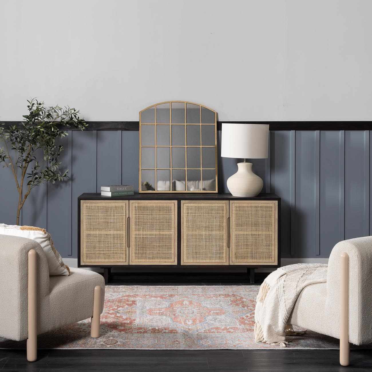 Living room scene with a Rust Maayon Washable Rug, beige chairs, and a rattan cabinet against a blue wall. Roomscene-Rectangle