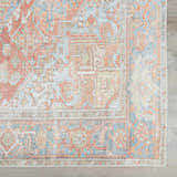 Close-up of the Rust Maayon Washable Rug. Features a traditional, vintage pattern in brick red, brown, and denim blue hues. Swatch