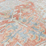Close-up of the Rust Maayon Washable Rug, featuring a traditional design in brick red, brown, and denim blue tones. Texture