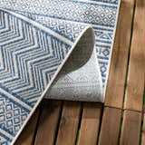 Close-up of the Madras Light Blue Green All Over Performance Area Rug showing its geometric pattern and texture. Fold