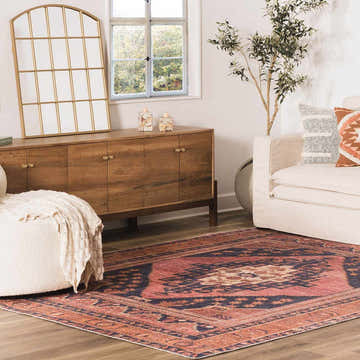 Living room scene with a Malamote Vintage Flat Pile Washable Rug in burnt orange and navy, styled with a white sofa and wooden cabinet. Roomscene-Rectangle