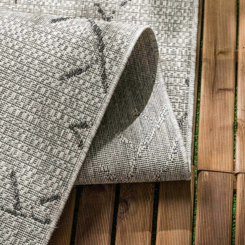 Close-up of the taupe and charcoal Marwood Nordic Performance Rug showing its woven texture and geometric pattern. Fold