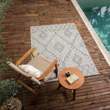 Outdoor scene with Marwood Nordic Performance Rug, chair, and side table by the pool. Roomscene-Rectangle