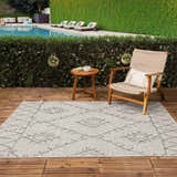 Outdoor patio scene with a Marwood Nordic Performance Rug, wooden furniture, and a pool in the background. Roomscene-Rectangle