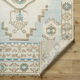 Close-up of McColl Hand Knotted Wool Blend Rug showing cream, brown, and teal geometric pattern and hand knotted construction. Fold