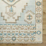 Close-up of McColl Hand Knotted Wool Blend Rug. Cream rug with brown and teal geometric, oriental-inspired pattern. Corner