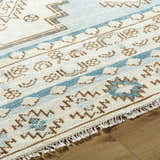 Close-up of the hand-knotted McColl rug. Wool blend rug in cream, brown, and teal with a Southwestern-inspired geometric pattern. Texture