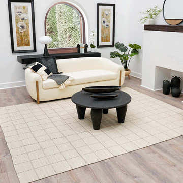 Living room with cream sofa, black coffee table, and Nissa Cream Checkered Wool Rug on light wood floors. Roomscene-Rectangle