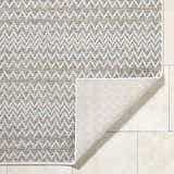 Close-up of the Alazne Ivory Area Rug showing its chevron pattern and ivory, sage, tan, and taupe colors. Fold