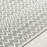 Close-up of the Alazne Ivory Area Rug showing the ivory geometric pattern and sage, tan, and taupe woven texture. Texture