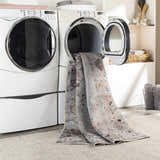 Midtown Washable Area Rug in a laundry room being pulled from the dryer, showing brick red, charcoal, and gray colors. Washing-Machine