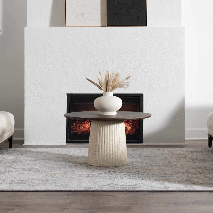 Living room scene with a beige and gray Minoa Area Rug under a round coffee table near a fireplace. Roomscene-Rectangle