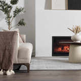 Living room scene with a neutral sofa, fireplace, and the beige Minoa Area Rug adding subtle pattern to the floor. Roomscene-Rectangle