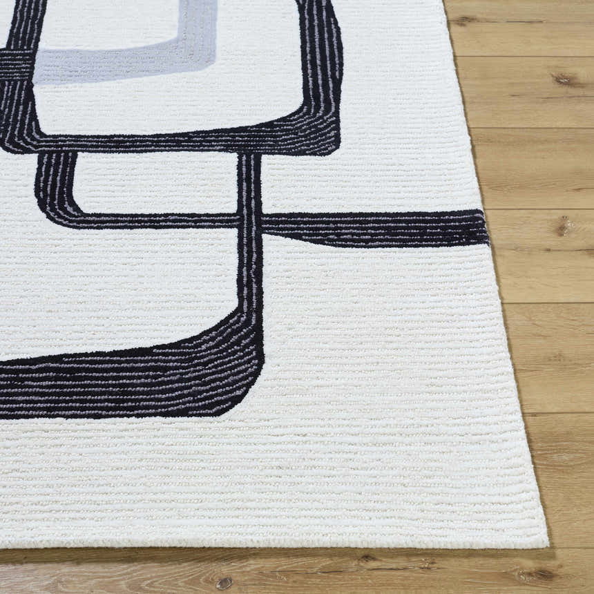 Close-up of the Ulfah Area Rug showing its ash and jet black geometric design and hand-tufted wool texture. Front