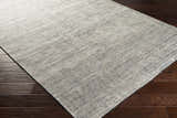 Close-up of the hand-knotted Molena Area Rug. Contemporary style with denim, ink blue, and light olive tones. 90% wool texture. Corner
