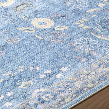 Close-up of the Meyly Blue Washable Area Rug, featuring a traditional floral pattern in slate blue, silver gray, and cream. Texture