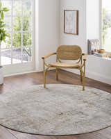 Light-filled room with a round Marli Thick Luxe Area Rug in gray and brown, paired with a woven chair on wood floors. Roomscene-Round
