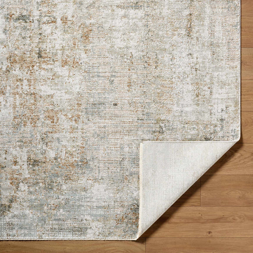 Close-up of the Marli Thick Luxe Area Rug showing its charcoal, cream, and brown distressed pattern and woven texture. Fold