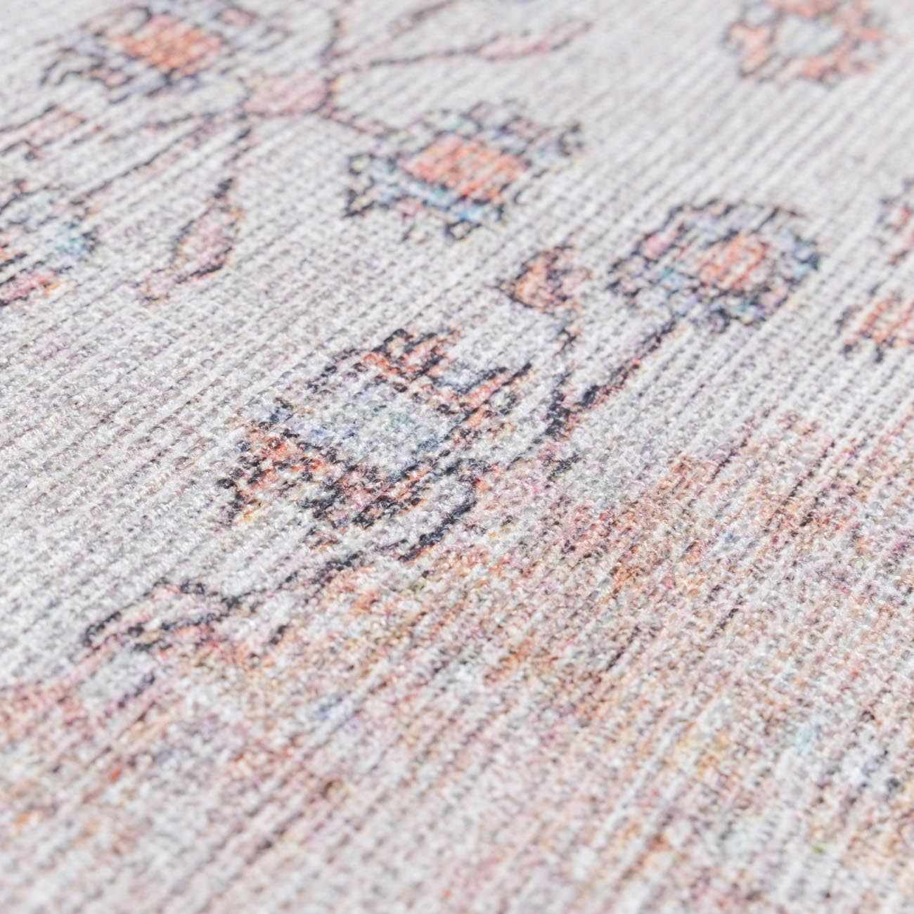Close-up of the Moora Washable Area Rug showing its chenille texture and floral pattern in aqua, blush, and coral tones. Texture