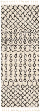Close-up of the Muni Berber Shag Rug. Charcoal and light beige diamond pattern with tassels. Bohemian style. Design-Runner-2773