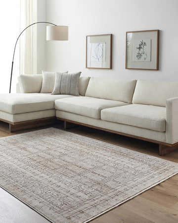 Living room with a cream couch and the Usonia Frank Lloyd Wright USO-2304 area rug in dark red, gray, and white. Roomscene-Rectangle