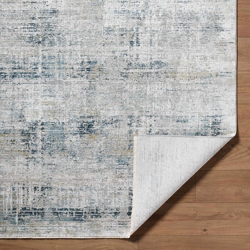 Close-up of the Neron Thick Luxe Abstract Rug showing its blue, charcoal, cream, and gray pattern and texture. Fold